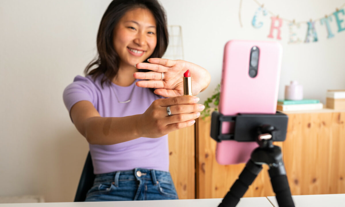 Femme présentant un rouge à lèvre face caméra